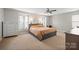Spacious bedroom with neutral carpeting, ceiling fan, and large windows providing plenty of natural light at 10241 Barrands Ln, Charlotte, NC 28278