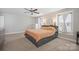 Comfortable bedroom features a ceiling fan, neutral carpeting, large windows, and a platform bed with built-in storage at 10241 Barrands Ln, Charlotte, NC 28278