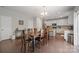 Bright, open dining area with a wooden table, seating for six, and connecting to a kitchen with white cabinets at 10241 Barrands Ln, Charlotte, NC 28278
