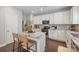 Modern kitchen boasts white cabinets, stainless steel appliances, a center island with seating, and mosaic backsplash at 10241 Barrands Ln, Charlotte, NC 28278