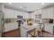 Stylish kitchen featuring white cabinets, stainless steel appliances, center island with seating, and modern mosaic backsplash at 10241 Barrands Ln, Charlotte, NC 28278