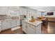 Open concept kitchen and dining area with white cabinets, center island, modern appliances, and wood dining table at 10241 Barrands Ln, Charlotte, NC 28278