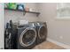 Modern laundry room featuring a washer, dryer, tile flooring and shelving at 10241 Barrands Ln, Charlotte, NC 28278