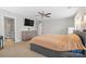 Spacious main bedroom featuring neutral walls, ceiling fan, TV, dresser and an ensuite bathroom at 10241 Barrands Ln, Charlotte, NC 28278