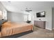 Spacious main bedroom featuring neutral walls, ceiling fan, TV, dresser and a window at 10241 Barrands Ln, Charlotte, NC 28278