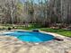 Inviting backyard with a freeform pool, a stone waterfall feature, manicured landscaping, and plenty of room to relax at 1041 Crofton Dr, Waxhaw, NC 28173