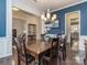 Elegant dining room with wainscoting and hardwood floors, featuring a wooden table and a stylish chandelier at 1041 Crofton Dr, Waxhaw, NC 28173