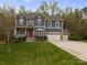 Charming two-story home with a landscaped yard, featuring a three-car garage and a welcoming front porch at 1041 Crofton Dr, Waxhaw, NC 28173