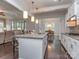 Open-concept kitchen with a large island, white cabinets, stainless appliances, and hardwood floors extending to a living area at 1041 Crofton Dr, Waxhaw, NC 28173