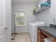 Laundry room featuring a window, washer and dryer, tile floor and storage shelving at 1041 Crofton Dr, Waxhaw, NC 28173