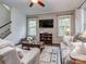 Cozy living room with a ceiling fan, decorative rug, and large windows for plenty of light at 1041 Crofton Dr, Waxhaw, NC 28173