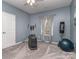 Carpeted room with exercise equipment, window and curtains, and light blue walls at 1041 Crofton Dr, Waxhaw, NC 28173
