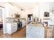 Bright kitchen boasts white cabinets, marble island, and stainless appliances with views at 118 Heathrow Ln, Statesville, NC 28677