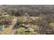 Aerial view of a home with a pool and outbuildings surrounded by mature trees and lush landscaping at 119 Old Hearth Rd, Clover, SC 29710