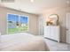 Comfortable bedroom with a large window, dresser, and neutral color palette at 12140 Devon Square Ct, Charlotte, NC 28262
