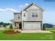 Charming two-story home with a welcoming front porch, manicured lawn, and a two-car garage at 12140 Devon Square Ct, Charlotte, NC 28262