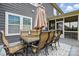 Outdoor dining area with a stone table, seating, and a partial view of the backyard at 1276 Stonecrest Blvd, Tega Cay, SC 29708