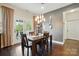 Cozy dining room with hardwood floors, stylish lighting, and French doors leading to the outdoors at 1276 Stonecrest Blvd, Tega Cay, SC 29708