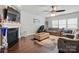 Comfortable living room featuring a fireplace, ceiling fan, and hardwood floors at 1276 Stonecrest Blvd, Tega Cay, SC 29708