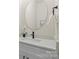Elegant powder room with a modern faucet, vanity, oval mirror, and quartz countertop at 130 Big Oak Ln, Statesville, NC 28625