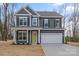 Two-story home features gray siding, black shutters, a two-car garage, and a bright green front door at 130 Big Oak Ln, Statesville, NC 28625
