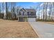 Two-story home features gray siding, black shutters, a two-car garage, a bright green front door, and a large yard at 130 Big Oak Ln, Statesville, NC 28625