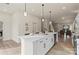 Open kitchen features white cabinets, quartz countertops, pendant lighting and stainless steel appliances at 130 Big Oak Ln, Statesville, NC 28625
