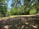 Large, grassy backyard with mature trees and a chain link fence in a quiet location at 1500 Griffith Rd, Monroe, NC 28112