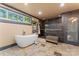 Luxurious bathroom with a standalone tub, modern shower, sleek tile work, and natural light from the window at 1500 Griffith Rd, Monroe, NC 28112