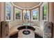 Charming breakfast nook features a built-in banquette, large windows, and unique chandelier, ideal for casual dining at 1500 Griffith Rd, Monroe, NC 28112