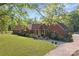Charming red brick home with mature trees, lush green lawn and meticulous landscaping creating serene curb appeal at 1500 Griffith Rd, Monroe, NC 28112