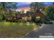 Charming brick home with lush landscaping, front lawn, and driveway at dusk at 1500 Griffith Rd, Monroe, NC 28112