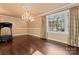 Spacious room featuring hardwood floors, natural light, decorative chandelier, and room for excercise equipment at 1500 Griffith Rd, Monroe, NC 28112
