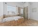 Bright bathroom featuring a large soaking tub, glass enclosed shower and tiled flooring at 15009 Lisha Ln, Charlotte, NC 28277