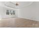 Large bedroom featuring trey ceilings, hardwood floors, and large windows at 15009 Lisha Ln, Charlotte, NC 28277