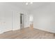 Bright bedroom featuring light hardwood floors, white walls, and ample closet space at 15009 Lisha Ln, Charlotte, NC 28277