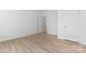 Spacious bedroom with light hardwood floors, white walls, and two bright white doors at 15009 Lisha Ln, Charlotte, NC 28277