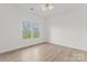 Sunlit bedroom featuring hardwood floors and double windows overlooking mature trees at 15009 Lisha Ln, Charlotte, NC 28277