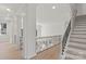 Bright hallway with decorative pillars, iron railing, and hardwood floors at 15009 Lisha Ln, Charlotte, NC 28277