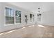 Living room features hardwood floors, a chandelier, many windows, and a glass door at 15009 Lisha Ln, Charlotte, NC 28277