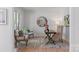 Brightly lit office space with hardwood flooring, round mirror, lamp, writing desk and two chairs at 15009 Lisha Ln, Charlotte, NC 28277