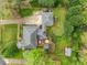 Aerial view of a property with a large gray roof, wooden deck with seating, and mature trees in a landscaped yard at 16421 Breckshire Dr, Huntersville, NC 28078