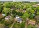 Aerial view of residential homes with swimming pools, lush greenery, and manicured lawns in a tranquil neighborhood near a lake at 16421 Breckshire Dr, Huntersville, NC 28078