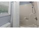 Bathroom featuring a shower and tub combination, along with a window and shower curtain at 16421 Breckshire Dr, Huntersville, NC 28078