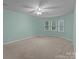 Spacious bedroom featuring plush carpeting, a ceiling fan, and plenty of natural light at 16421 Breckshire Dr, Huntersville, NC 28078
