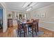 Dining room featuring hardwood floors, modern lighting and a large window with backyard views at 16421 Breckshire Dr, Huntersville, NC 28078