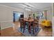 Open dining room with hardwood floors, modern chandelier, and seating for six at 16421 Breckshire Dr, Huntersville, NC 28078