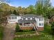 Charming two-story home with a brick foundation, white siding, covered front porch, and a separate two-car garage at 16421 Breckshire Dr, Huntersville, NC 28078