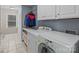 Functional laundry room equipped with modern washer and dryer, cabinetry and natural light at 16421 Breckshire Dr, Huntersville, NC 28078