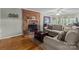 Inviting living room featuring a brick fireplace, wood floors, and a comfortable seating area at 16421 Breckshire Dr, Huntersville, NC 28078